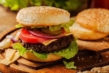 Homemade, beef hamburger with cheese and vegetables.