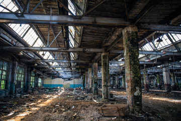 Fototapeta na wymiar Abandoned ruined industrial warehouse or factory building inside, corridor view with perspective, ruins and demolition concept