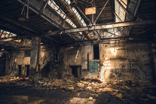 Abandoned ruined industrial warehouse or factory building inside, corridor view with perspective, ruins and demolition concept