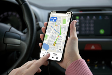 women hand holding phone with app navigation map on screen