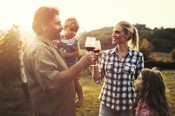 Wine grower family in vineyard before harvesting
