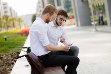 Business colleagues sitting on bench