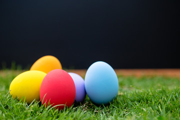 Colorful Easter eggs background. holiday, easter background. Colorful easter eggs on the green garden yard. symbol of easter's day festival. vivid color natural background. festive wallpaper.