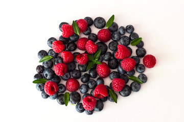 Blueberries and raspberries on white background.