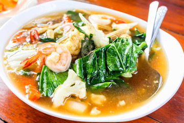 Close up of Fried noodle with seafood and broccoli on white dish