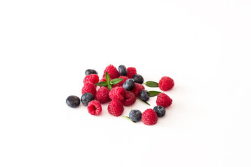 Blueberries and raspberries on white background.