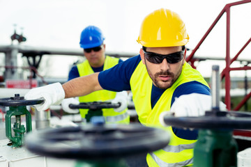 Oil worker closes the valve on the oil pipeline