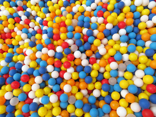 Multi-colored plastic balls on kids playground. Balls for fun and jumping, colorful festive background