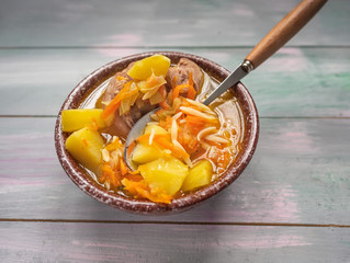 Hot soup in a deep ceramic brown bowl