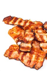 Grilled bacon on white. Crispy Cooked Bacon On Table. Unhealthy food. Risk of obesity. Homemade barbecue.