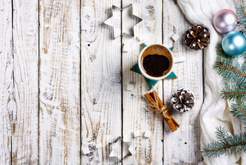 Cup of hot coffee with sugar and cinnamon on old wooden table with spruce branches.