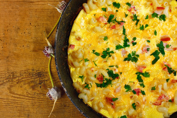 Traditional rustic omelette with bacon, pasta and greens .  Copy space