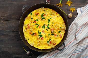 Traditional rustic omelette with bacon, pasta and greens .  Copy space