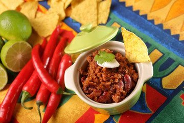 Chili con carne with nachos on tablecloth in spanish pattern