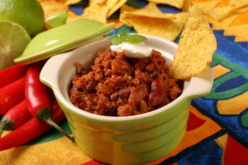 Chili con carne with nachos on tablecloth in spanish pattern