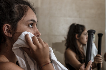 Mujer joven limpiando el sudor mientras descansa después del entreno en el gimnasio