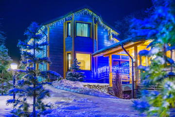 Winter  Cottage village in winter. Winter landscape with houses. Christmas night. The houses are decorated for the New Year holiday. The house is covered with snow. 