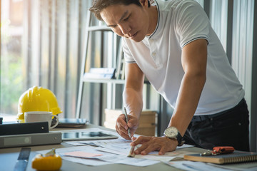 Architects,engineer holding pen pointing equipment architects On the desk with a blueprint in the office.Architect design concept.
