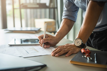 Fototapeta premium Businessman's hand pointing at business document during discussion at his working place in office.
