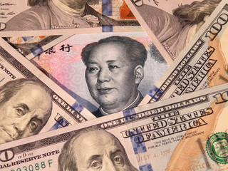 Chinese yuan surrounded by US dollars. Concept for sanctions and trade war between China and the USA