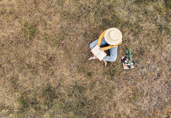 A girl in a hat reading a book - a top view