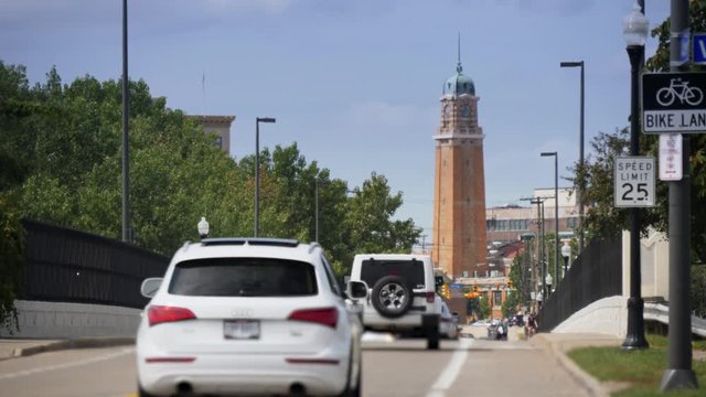 A long establishing shot of traffic and pedestrians along Abbey Avenue in Cleveland, Ohio with the West Side Market tower in the distance.  	