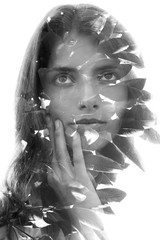 Double exposure portrait of young girl with big eyes and long wavy hair combined with leaves...