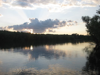  The sun breaks through thunderclouds at sunset. View of the bank of the Ob river.