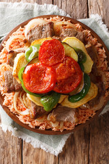 Tasty Lebanese recipe maklouba: rice with beef, eggplant, pepper, onions and tomatoes close-up. Vertical top view