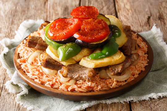 Home Arabic cuisine: Maklouba or Makloubeh or Makloubi rice with beef and vegetables close-up on a plate. horizontal