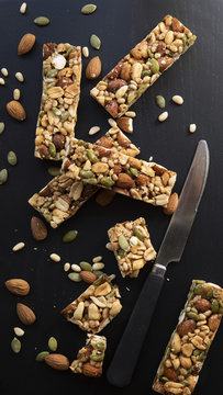  Nut and Seed Bars with a knife on a black blackground.