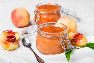 Homemade peach jam with organic fruit. Sweet preserves on a light background