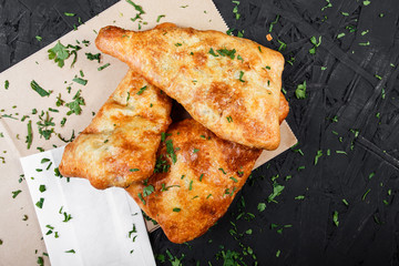Georgian khachapuri - flatbread with cheese on dark wooden background. Homemade food