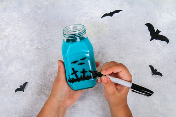 Handicraft from a jar. Bats on a light table. The concept for Halloween. DIY.