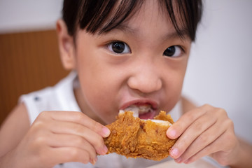 Asian Chinese little girl eating fried chicken