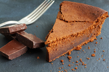 Chocolate cake with dark bitter chocolate and silver fork, high angle view, close-up