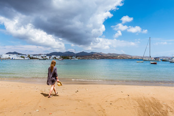 Pretty young woman on the summer beach in Pollonia village. Milos island, Greece