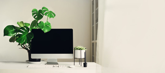 Designer workspace. Banner. Minimalistic home office. Blank screen desktop computer, Mockup desktop computer, lamp, graphics tablet, keyboard, mouse, pen, succulent plant on white desk. Copy space