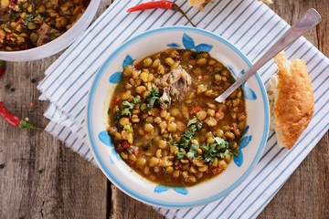 Delicious country soup from a mixture of legumes in a plate is ready to be eaten for lunch