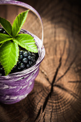 Sweet blackberries in basket on vintage wooden board