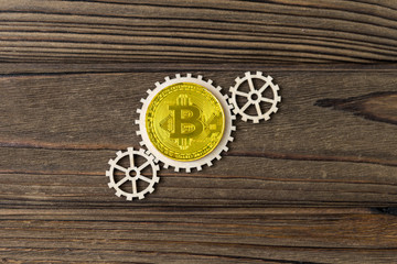 bitcoin, gears on a wooden background. virtual money, currency. finance.