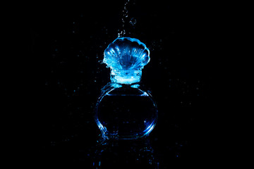 water splash drop with glass bottle of cosmetic perfume smell luxury on black background