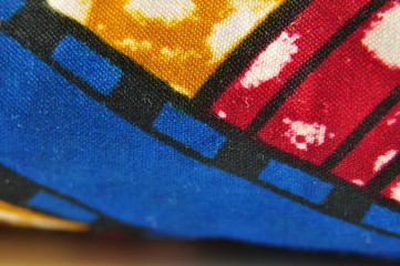 macro de tissu africain, détail du motif en jaune rouge et bleu