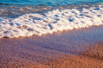 Sea foam from the wave rolling on the beach