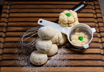 Home-made cookies displayed on a wooden board with baking utensils
