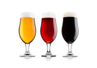 Cold glasses of lager stout and red beer with dew