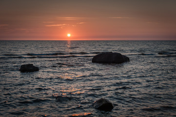 Fototapeta na wymiar Sunset. Wild rocky coastline of the Baltic sea in summer. Kurmrags, Latvia.