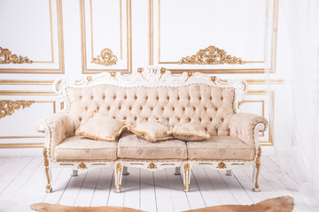 Antique luxury sofa against royal wall decoration. - obrazy, fototapety, plakaty