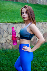 The girl athlete follows her diet, she drinks water after training.