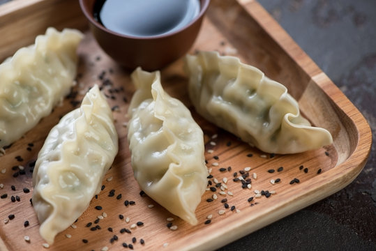 Close-up of steamed korean dumplings on a wooden serving tray, selective focus
